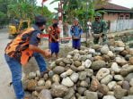 Anggota Satgas TMMD 109 Kodim 0201/BS Bersama OKP Mengangkat Batu Untuk Pondasi Bronjongan